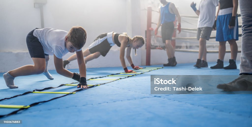 Group Of Kids Training Boxing Group of kids training boxing in the gym with box coach. Combat sport and kids sport concept. Sport Stock Photo