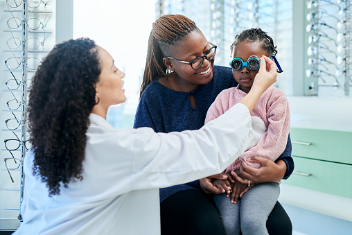 Women, girl or mother with children optometrist for eye test, healthcare wellness exam or vision glasses fitting. Smile, happy or mom with kid optometry or prescription lens in eye care medical store