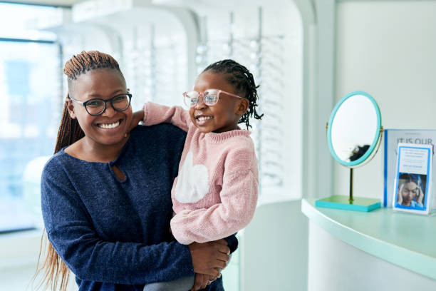 lunettes, portrait de mère et d’enfant, heureux pour les soins oculaires et le bien-être des yeux ou de la vision. femme noire, enfant et bonheur ou sourire pour les lunettes, les soins de la vue et la monture de lentilles dans le bureau de l’optomé - young bird photos et images de collection