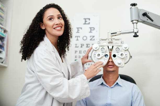 istock Optometry, test eyes and optician with a man, consulting and communication about inspection with machine. Medical, exam and optometrist with a patient for vision check or problem with results 1450677545