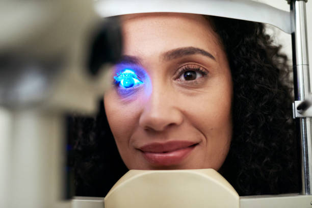 Vision eye exam, machine light and patient at eye care clinic for medical consultation, ocular healthcare or glaucoma test. Uv check, ophthalmology and black woman face with slit lamp to study cornea examen de la vista, luz de la máquina y paciente en la clínica de atención oftalmológica para consulta médica, atención médica ocular o prueba de glaucoma. revisión uv, oftalmología y rostro negro de mujer con lámpara de hendidura para estudiar l