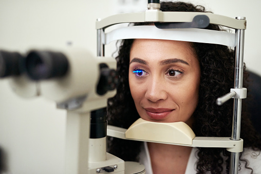 Woman, laser test and eye at optometrist , technology and healthcare for vision, eyesight and wellness in clinic. Female customer or patient in consultation for glaucoma, eye exam and eye care