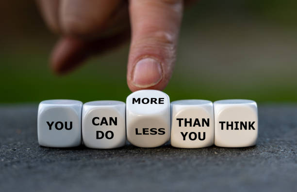 istock Hand turns dice and changes the expression 'you can do less than you think' to 'you can do more than you think'. 1450678175