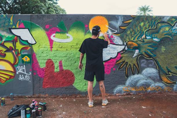 campo grande, Brazil – December 17, 2022: An artist creating graffiti on a wall in different colors