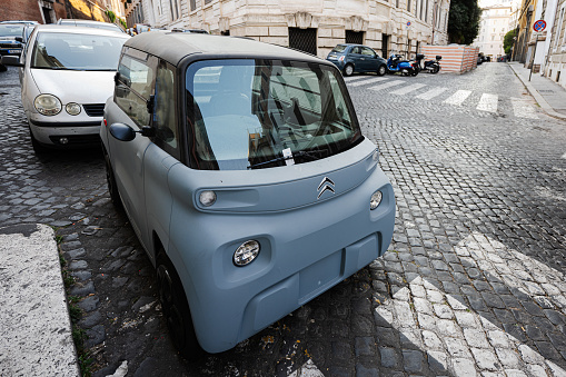 Rome, Italy - July 27, 2022: French small Citroen Ami electric two seater micro city car parked in Rome, Italy.