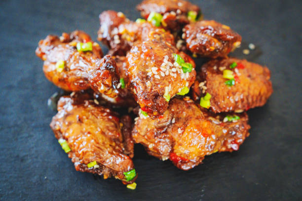 istock fried chicken with garlic and sesame in caramel on a black tray. 1450686397