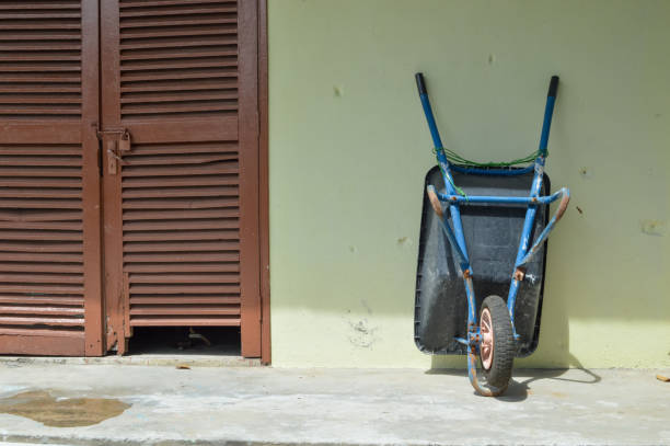 Wheelbarrow or construction cart laid on wall.