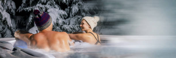 winter spa. couple relaxing in outdoor hot tub. banner with copy space stock photo