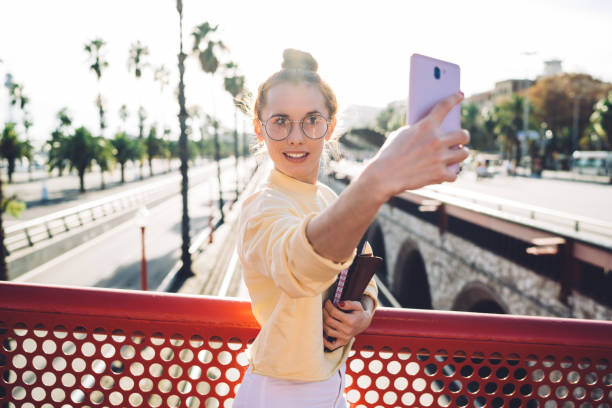 istock Young female student taking selfie on bridge 1450694497