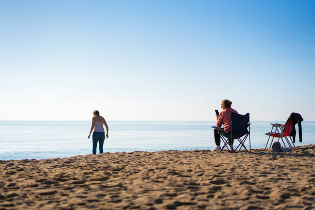 istock Two mature women spending time on the beach in autumn 1450694886