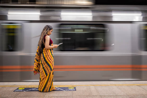 istock Indian girl using a digital tablet at metro station, India 1450705471