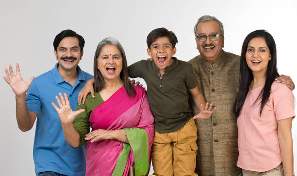Portrait of joyful multi generation Indian family posing on white background