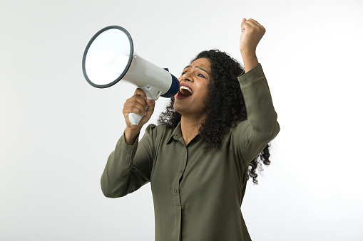 Angry businesswoman shaking fist and screaming into megaphone