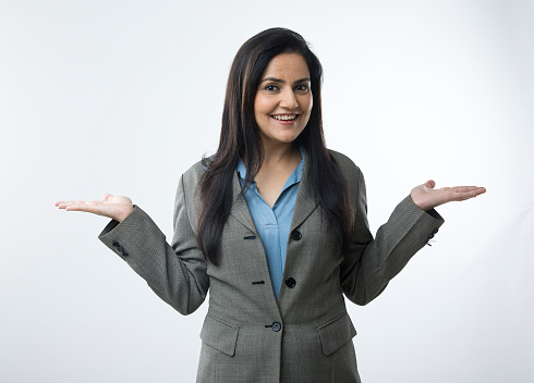 Portrait of businesswoman gesturing with open hand palms on white background