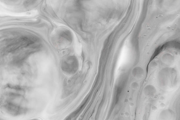 Macro close up depicting the abstract forms and shapes in a mixture of grey paint and oil.