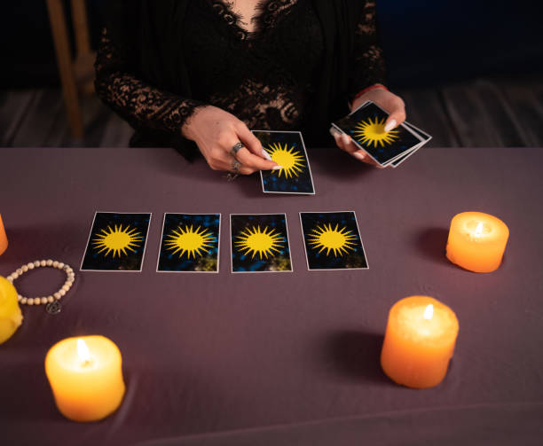 istock Fortune teller hands and tarot cards on wooden table. Divination 1450712284