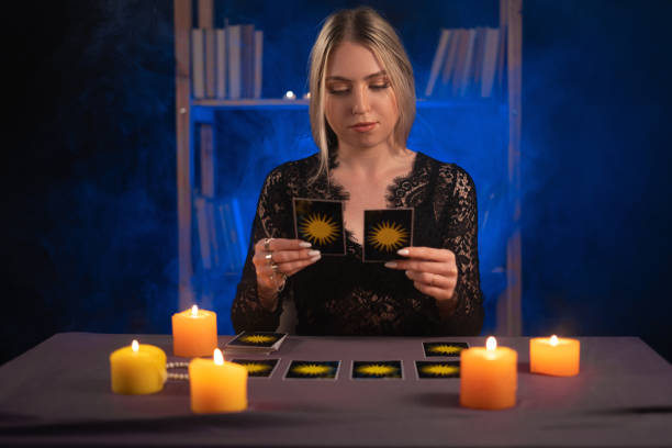 istock Female fortune teller read tarot cards to predict fortune. Future reading. Ritual candles burning, seance 1450712288