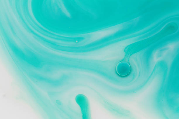 Macro close up depicting the abstract forms and shapes in a mixture of blue paint and oil.
