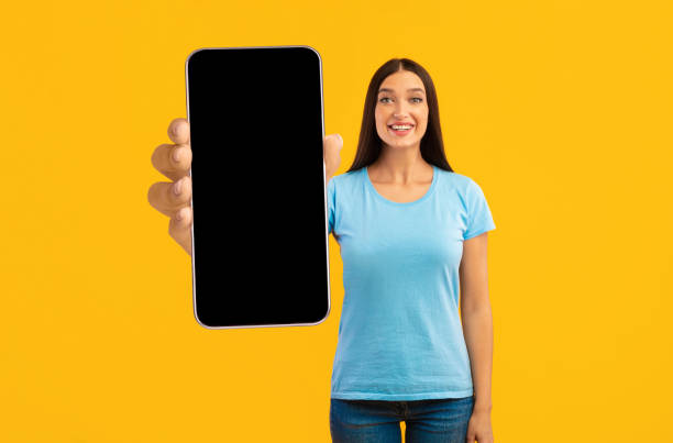 istock Mobile Mockup. Smiling Young Lady With Big Blank Smartphone In Hand 1450714180