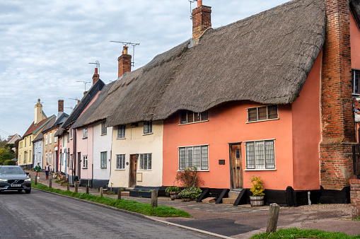 Traditional Suffolk cottages - some in shades of Suffolk Pink - lining Old Street, the main street in the village of Haughley in Suffolk, Eastern England on a November day.