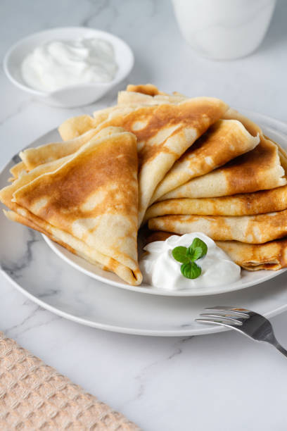 istock Stack of russian thin pancakes blini with fresh sour cream 1450723443