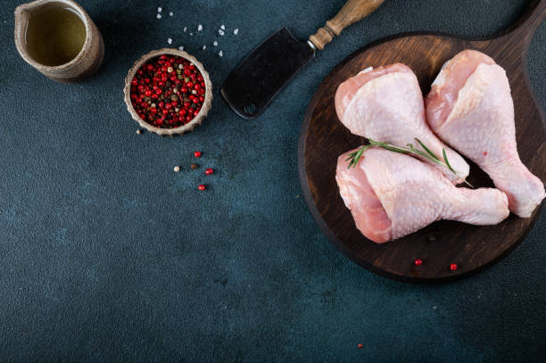 istock Raw uncooked chicken legs. meat with ingredients for cooking 1450725653