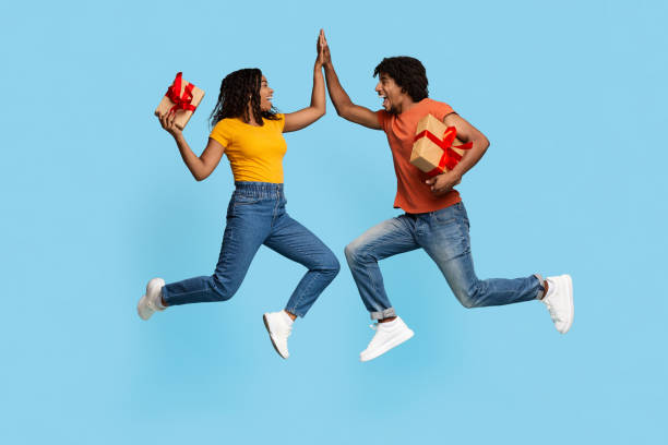 istock Happy man and woman with gift boxes giving high five 1450727200