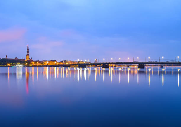Riga short before sunrise. The city lights are reflected from the old town and the bridge.