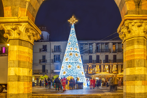 Christmas tree in Como (Italy) - city center with blurry (from motion) people. People take selfies and enjoy the approaching Christmas week . Unrecognizable persons