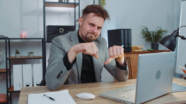 istock Upset businessman showing thumbs down, dislike bad work, disapproval dissatisfied feedback at office 1450745029
