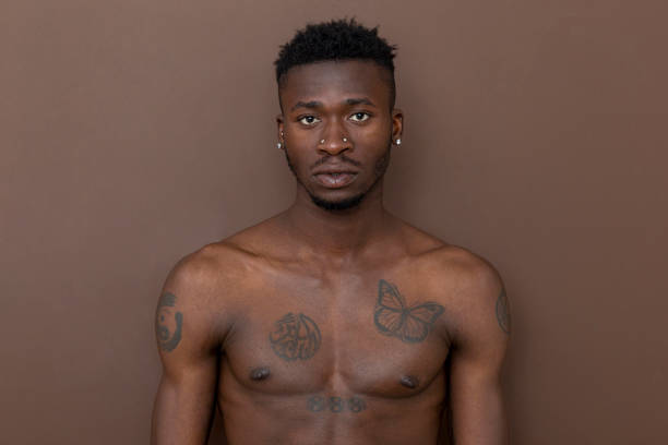 istock Fit, African black man looking at camera in front of brown wall. 1450745415