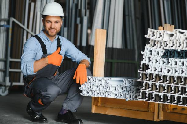 Factory for aluminum and PVC windows and doors production. Manual worker assembling PVC windows and doors