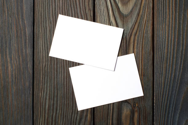 istock Two blank cards (business cards, tickets, flyers, invitations, coupons, banknotes, etc.) on dark wood 1450751231