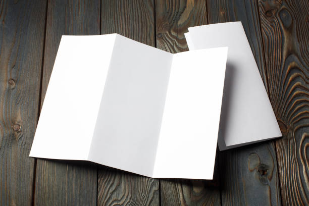 istock Folded sheets of white paper on dark wood 1450751323
