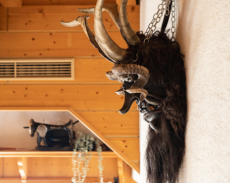 The mask of Krampus, a pagan Christmas devil, hangs on a wall in a ski hut, Austria, Salzburg. High quality photo