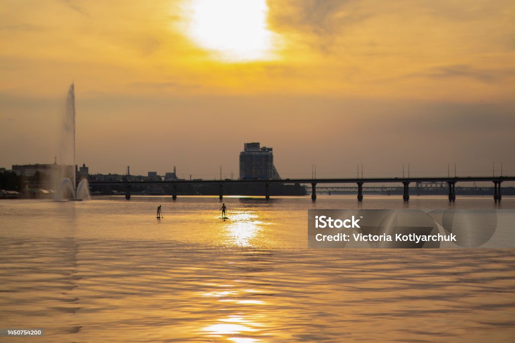 sunset in the city of Dnieper on the background of the bridge in the summer evening sunset in the city of Dnieper on the background of the bridge Arch - Architectural Feature Stock Photo