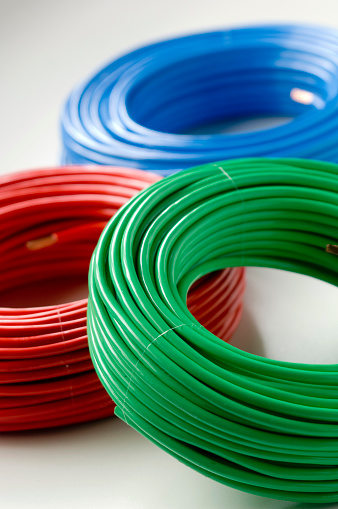 Multi colored electrical cable coils on a white background.