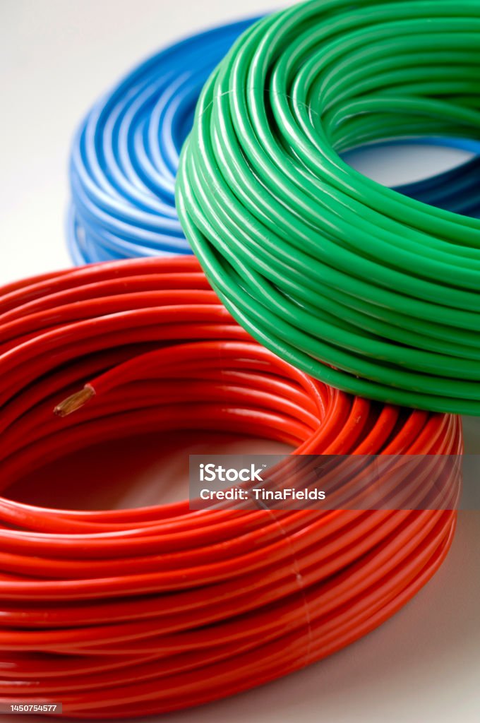 Power supply. Multi colored electrical cable coils on a white background. Cable Stock Photo