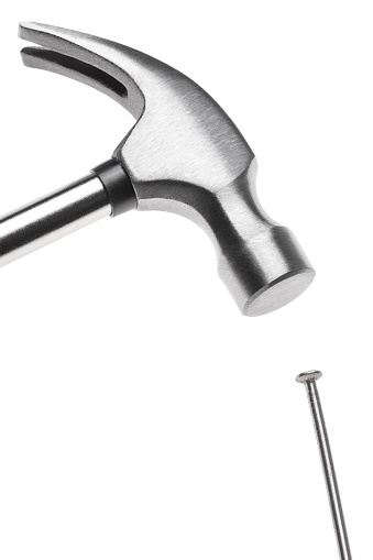 Hammer hitting a nail, isolated on white background