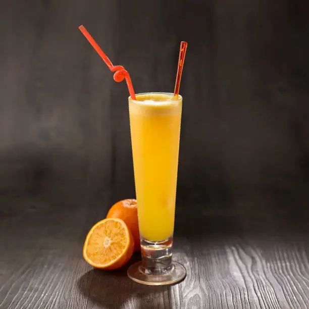 Orange Juice with straw served in glass isolated on table side view healthy morning drink