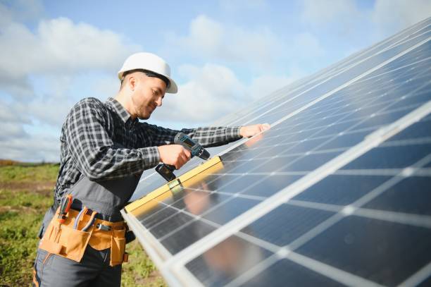 istock Male worker in uniform outdoors with solar batteries at sunny day. 1450757834