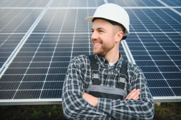 専門家が太陽電池の品質を検査しています。制服を着た労働者と装備を持ったヘルメット。エコロジー電力保存のコンセプト。 - engineer environment orange manual worker ストックフォトと画像