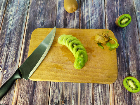 Kiwi tropical fruit cut into segments on a wooden board. Close-up