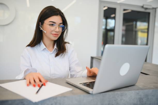istock friendly young woman behind the reception desk administrator 1450763958