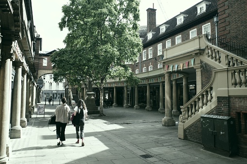 Cambridge, United Kingdom – June 20, 2022: A back view of two female shoppers walking on Sussex Street in Cambridge, UK