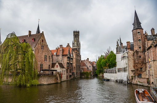 A beautiful view of the Rozenhoedkaai canal in Bruges with the belfry in the background