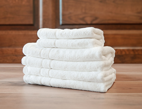 White towels stacked on a wooden table