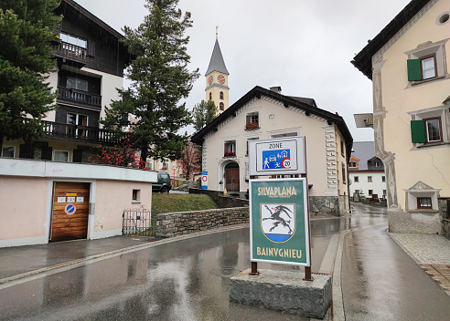 Silvaplana, Switzerland - October 2022: Entrance sign and townscape of Silvaplana in Engadin Valley, Switzerland on a rainy day.
