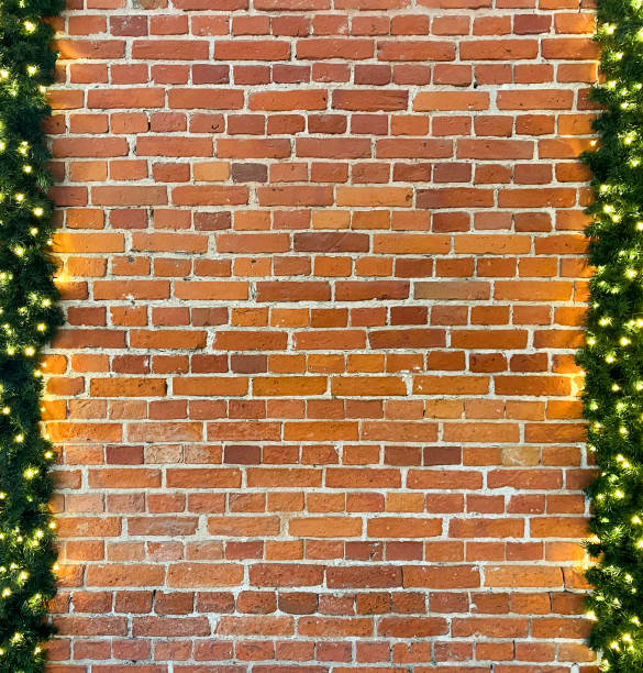 istock Brick wall branches of a Christmas tree with garlands, copy space mock up background 1450768948
