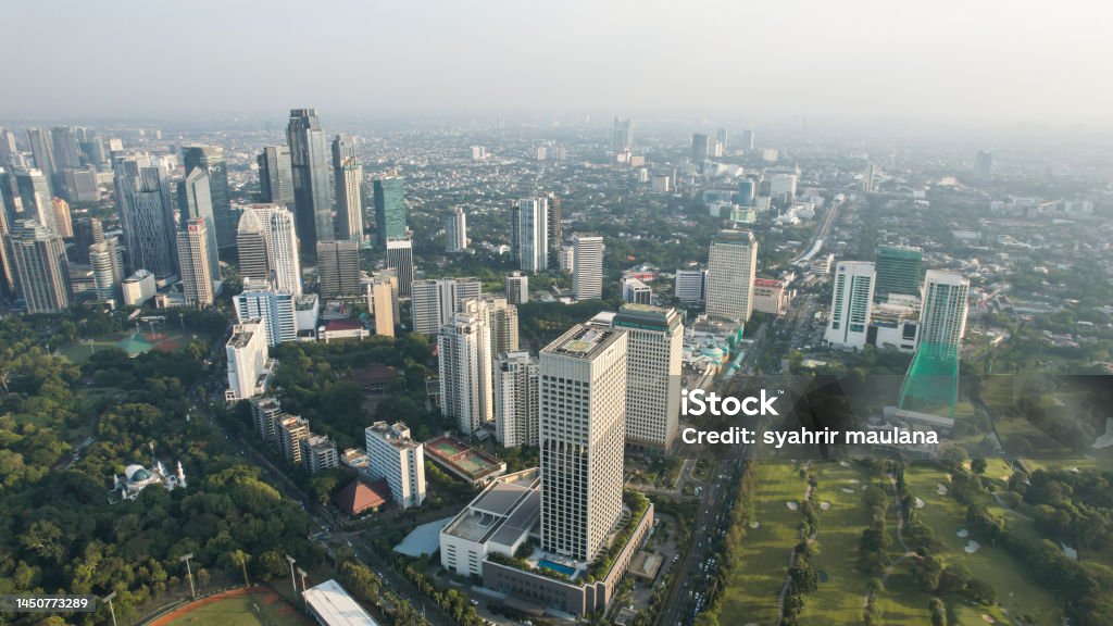 Aerial view of office buildings in Jakarta central business district Aerial view of office buildings in Jakarta central business district and noise cloud when sunset. Jakarta Stock Photo